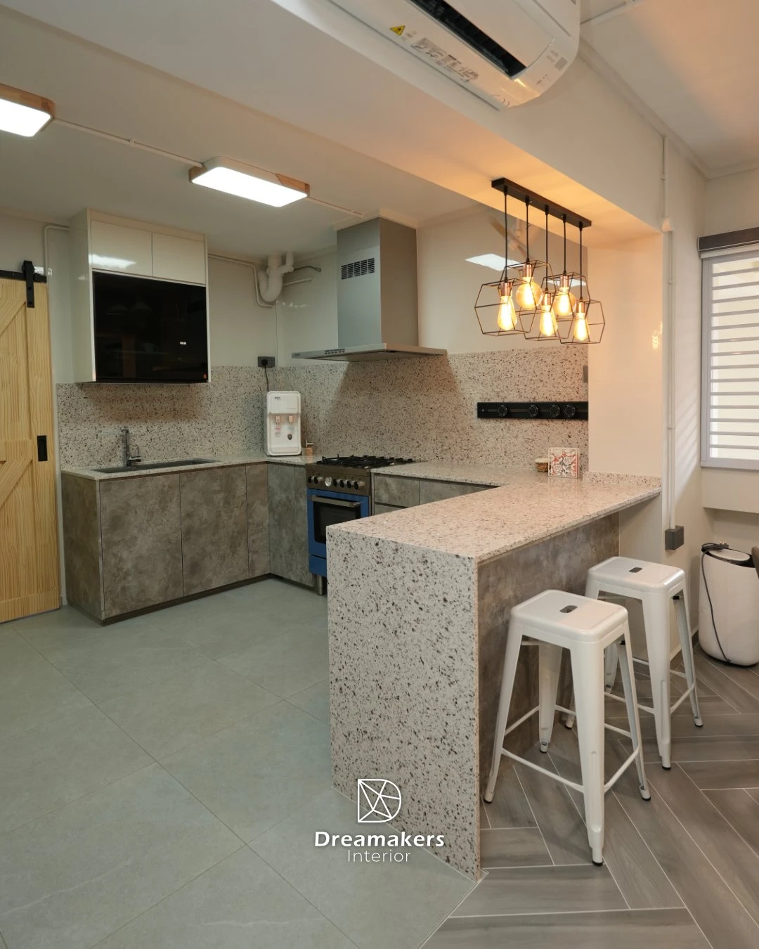 Open kitchen with granite breakfast peninsula and caged pendant lights in an executive apartment renovation at 332 Tampines Street 32