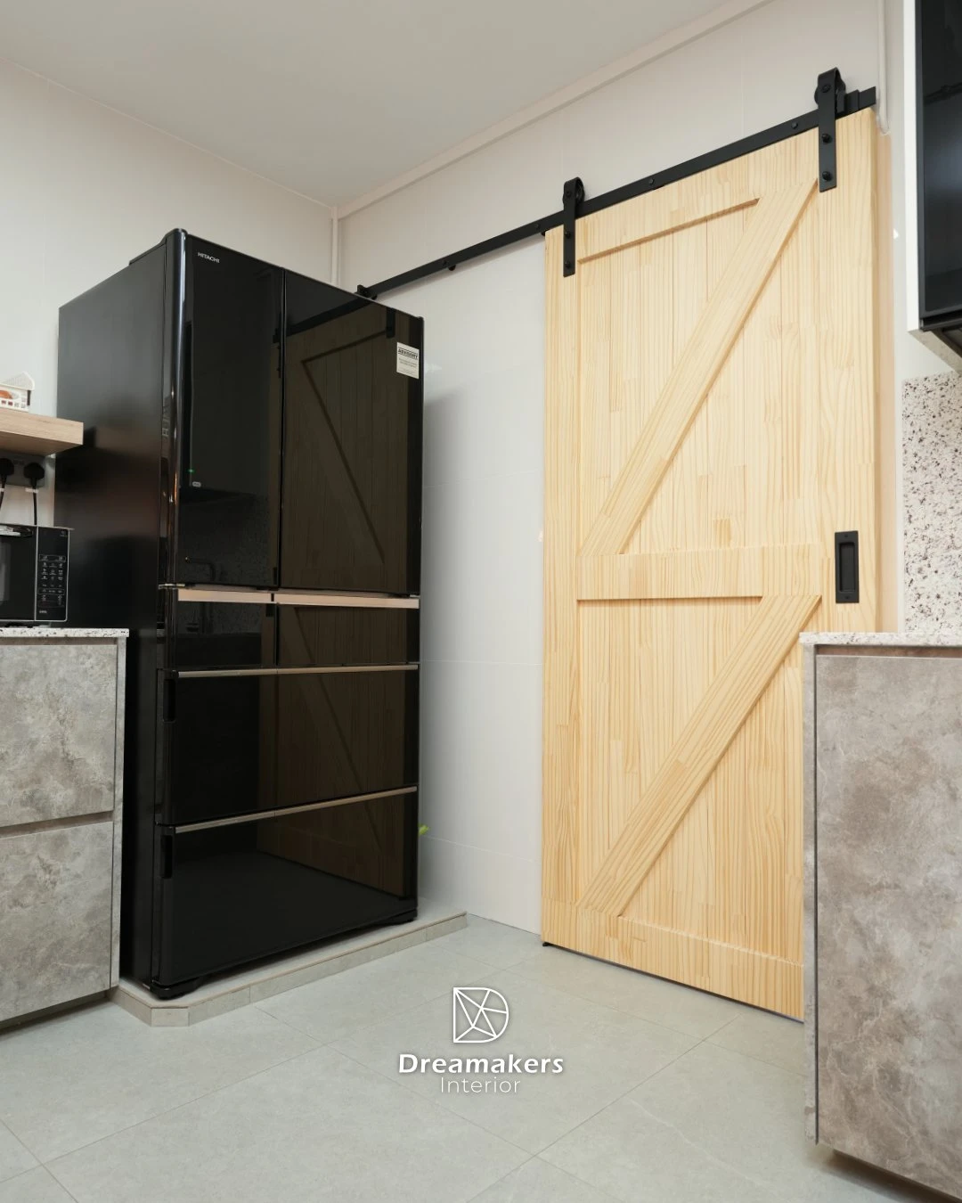 Pine barn door on black track beside the black fridge in the kitchen, Tampines executive apartment renovation