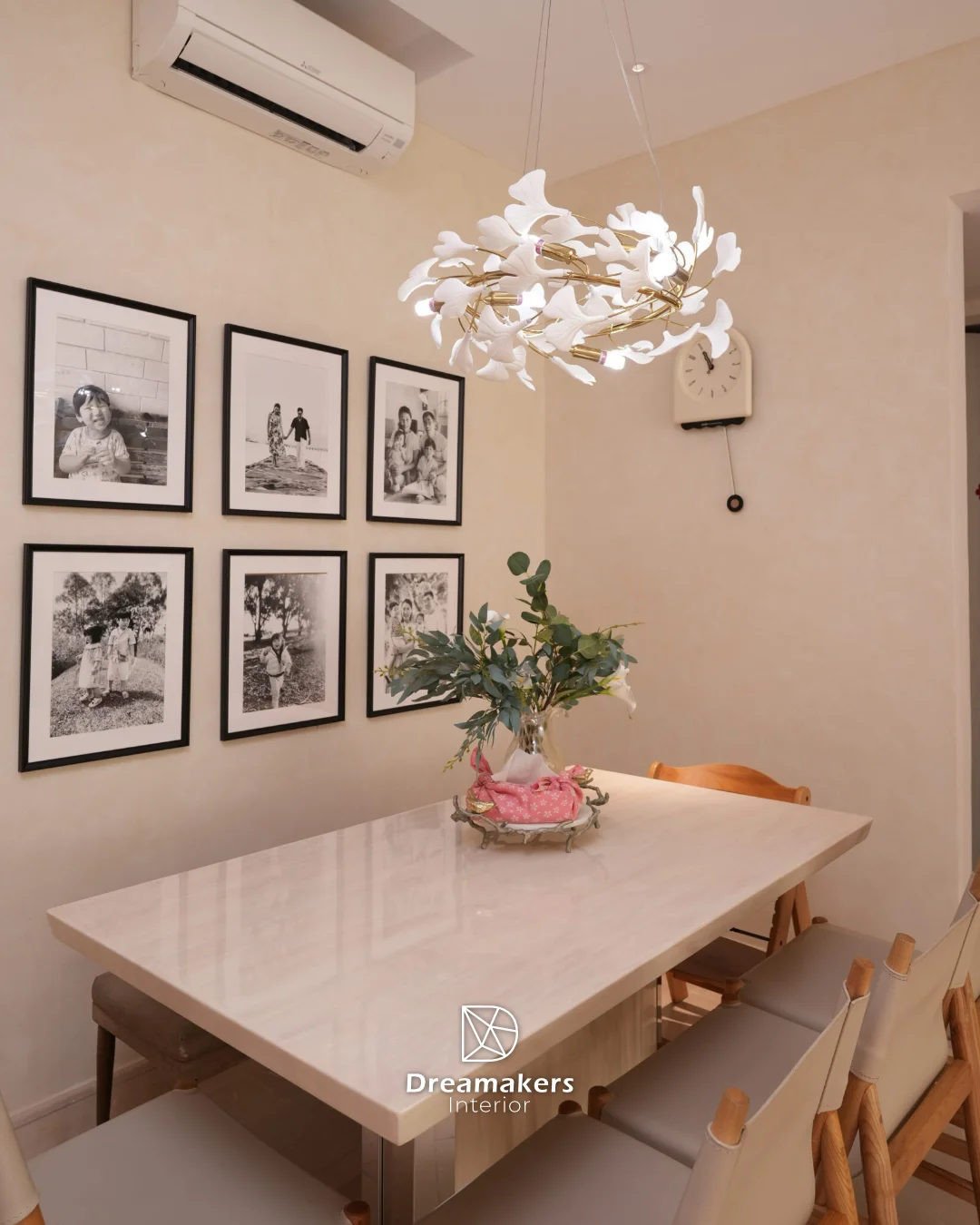 Dining area with pale wood table, canvas director's chairs and black-and-white family gallery wall, Duchess condo