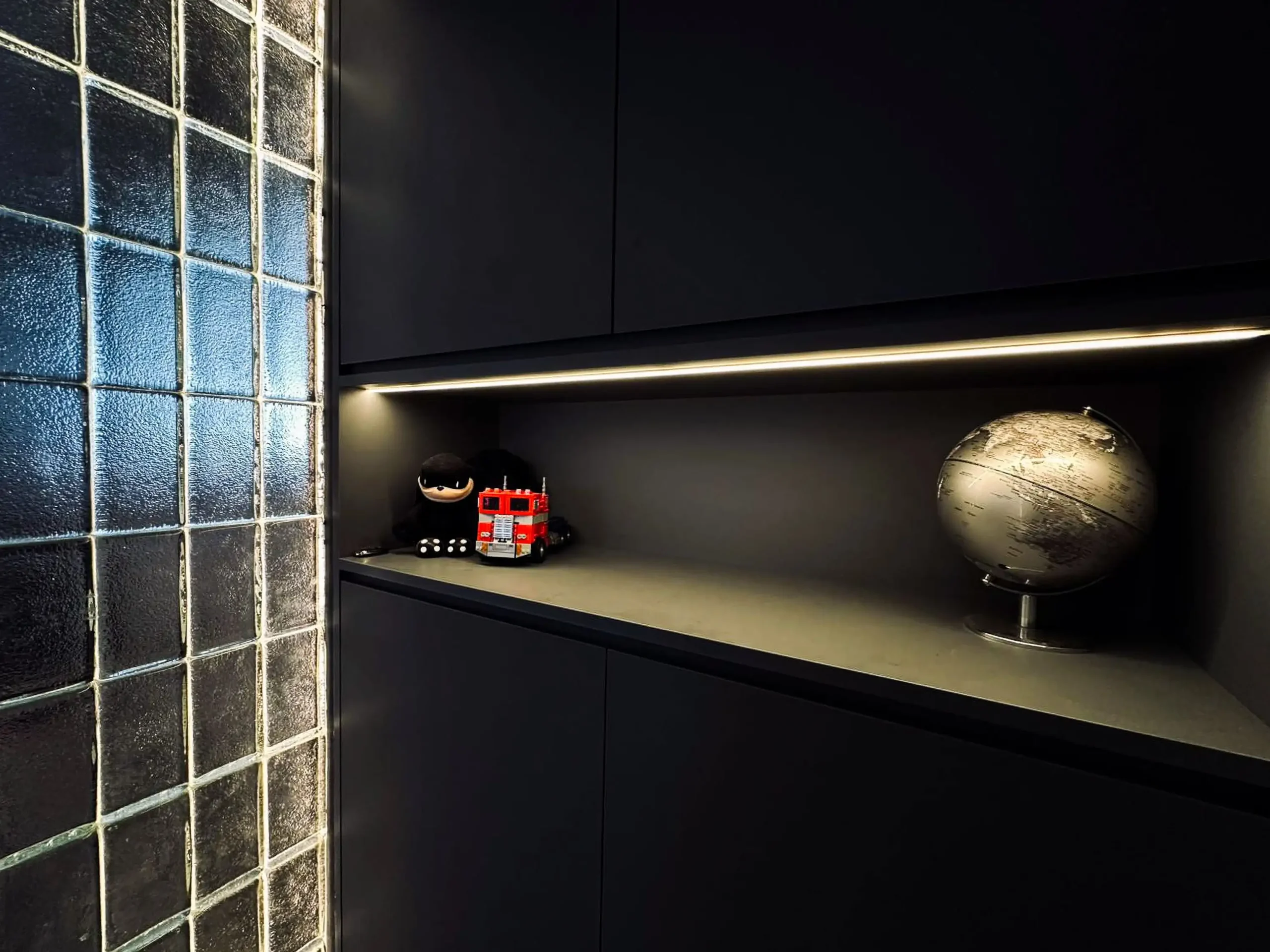 Matte black entryway cabinets with lit display niche beside the glass-block wall, 332 Hougang Ave 5