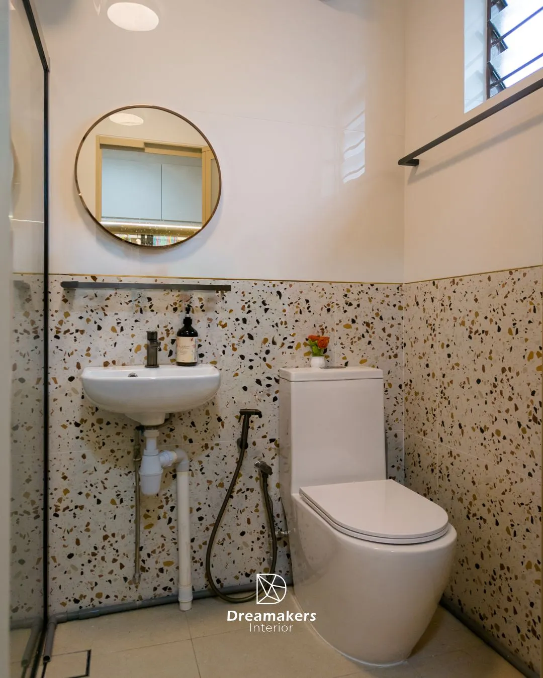 Bathroom with terrazzo-look tiles, gold trim and round gold-framed mirror, Jurong West 5-room resale HDB