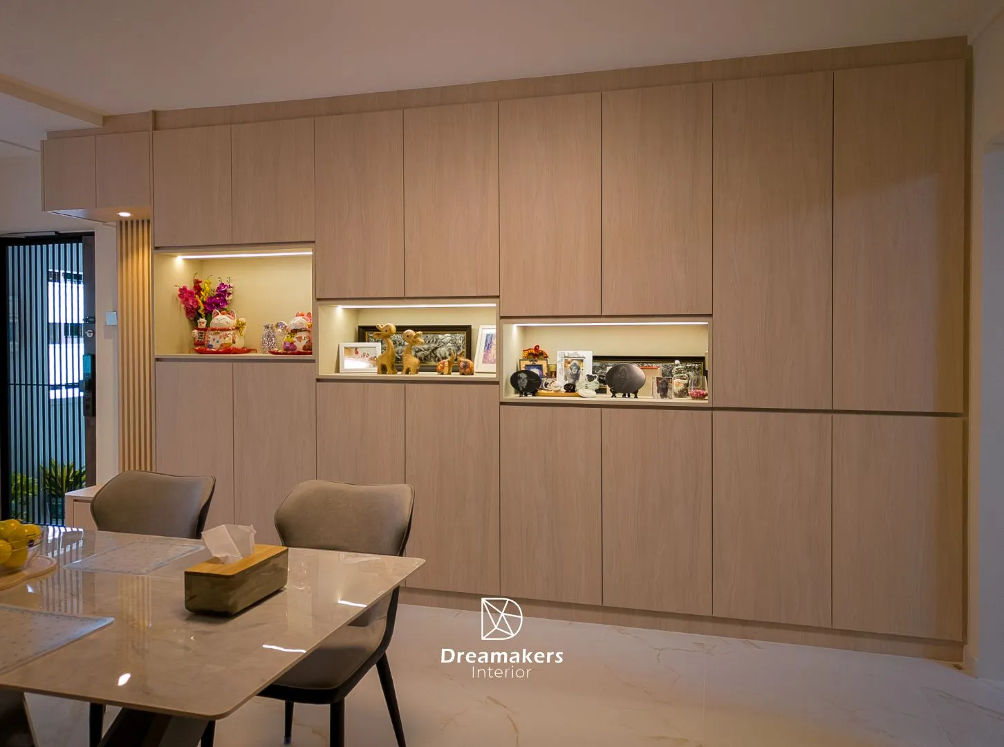 Floor-to-ceiling storage wall with lit keepsake niches beside the dining table, Jurong West 5-room resale HDB