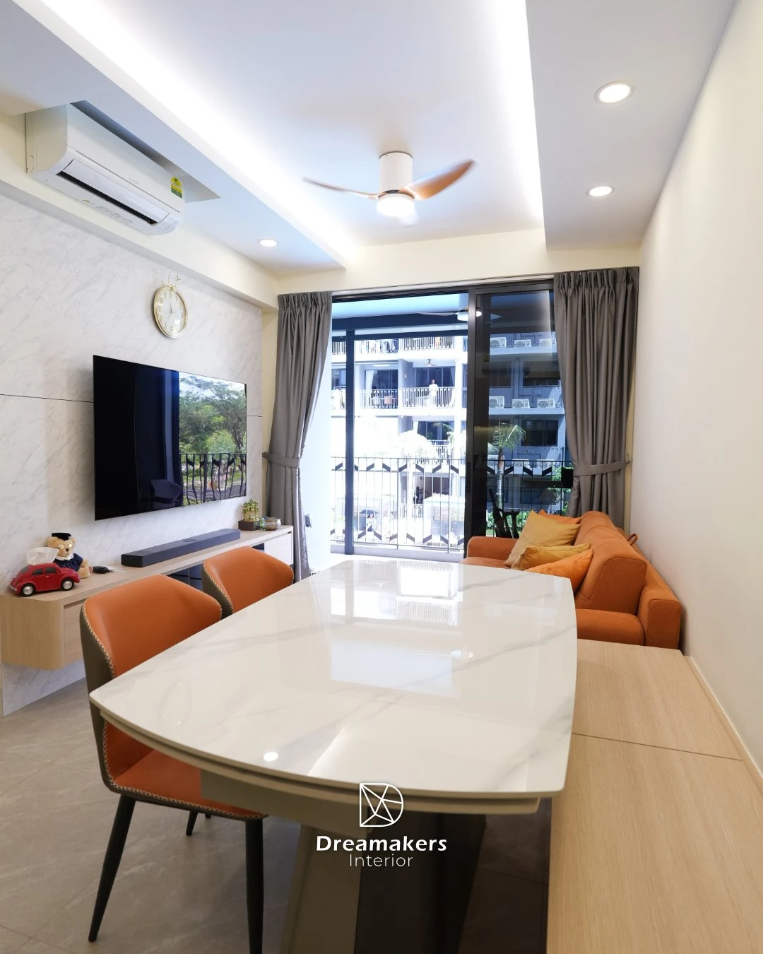 Bright living room with burnt-orange suede sofa and greenery view in an executive condo renovation at Parc Canberra, Sembawang